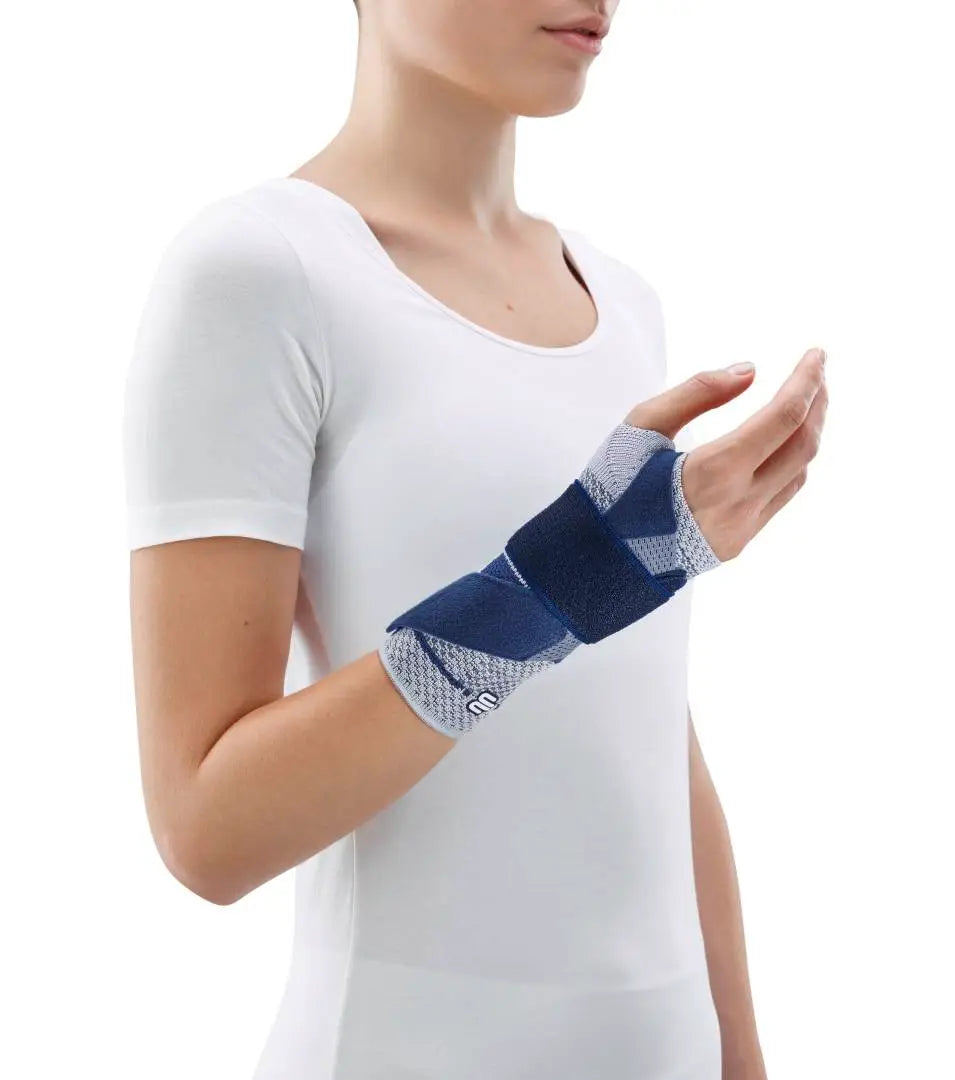Die Abbildung zeigt die Bauerfeind ManuTrain Bandage, eine stützende Bandage zur Stabilisierung des Handgelenks. Sie besteht aus elastischem, atmungsaktivem Material und ist anatomisch geformt, um sich optimal an das Handgelenk anzupassen. Die Bandage verfügt über integrierte, flexibel einsetzbare Pelotten, die gezielten Druck ausüben und die Muskulatur entlasten.