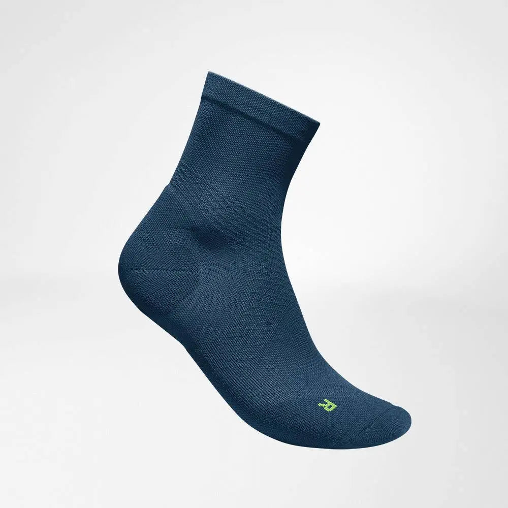 Die Abbildung zeigt die Bauerfeind Run Ultralight Mid Cut Socken, die speziell für Läufer entwickelt wurden. Diese Socken bestehen aus ultraleichtem, atmungsaktivem Material, das Feuchtigkeit effektiv ableitet und für ein angenehmes Tragegefühl sorgt. Die Mid Cut Länge bietet eine optimale Passform und leichten Schutz im Knöchelbereich. Zusätzlich unterstützen sie die Fußmuskulatur durch gezielte Kompression und fördern die Durchblutung, was Ermüdung und Blasenbildung vorbeugt.