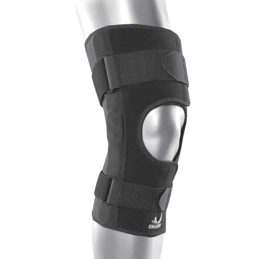 Das Bild zeigt die BioSkin Hinged Knee Sleeve Wraparound, eine stützende Kniebandage mit seitlichen Stäben zur Stabilisierung des Kniegelenks. Die Bandage besteht aus einem leichten, atmungsaktiven Material und ist so gestaltet, dass sie das Knie umschliesst und mit Klettverschlüssen individuell angepasst werden kann.